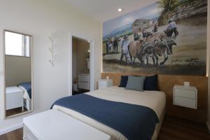 a bedroom with a bed and a painting on the wall at Quinta do Giz in Baião +47 photos