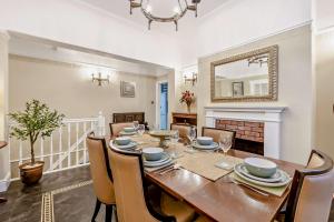 a dining room with a table and chairs and a mirror at Swan House in Southport