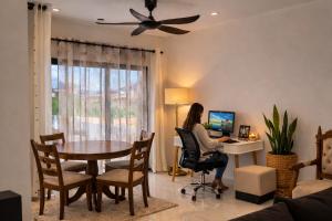 a woman sitting at a desk with a computer in a living room at Hill Venue in Coquinbourg