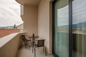a balcony with two chairs and a table at Hotel Pusi in Sauk
