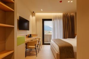a hotel room with a bed and a desk and a window at Hotel Pusi in Sauk