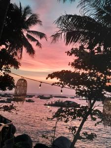 a sunset over the water with two hanging baskets at Home Sake Hòn Sơn in Lai Sơn