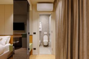 a hotel room with a toilet and a bedroom at Hotel Pusi in Sauk +50 photos