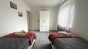 a bedroom with two beds and a window at Ferienwohnung City in Nollingen
