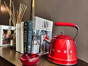 a red tea kettle sitting on a table with books at VILLA MARRONE - Relais - in Marsala