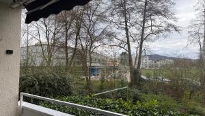 a balcony with a view of a building and trees at Ferienwohnung City in Nollingen