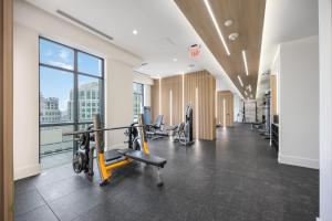 a gym with cardio equipment and a large window at Condo by CN Tower & Rogers Centre in Toronto