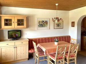 a dining room with a table and a television at Chalet Cristall Superior Appartement 3 in Leutasch
