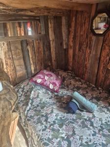 a small bed in a wooden cabin at Cabane en Cévennes in Saint-Germain-de-Calberte