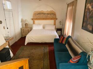 a bedroom with a white bed and a blue couch at Bisbee Grand Hotel, Saloon, and Music Venue in Bisbee