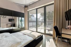 a bedroom with a bed and a desk and a large window at Shellter Resort Apartment by Solarento in Rogowo +76 photos