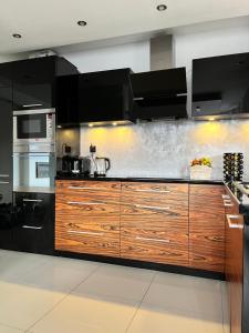 a kitchen with wooden cabinets and a stove at Ogrodowa Apartament in Ciechocinek