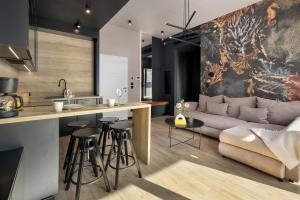 a kitchen and living room with a couch and a counter at Shellter Resort Apartment by Solarento in Rogowo