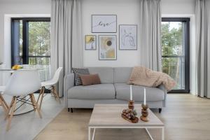a living room with a couch and a table at Shellter Resort Apartment by Solarento in Rogowo