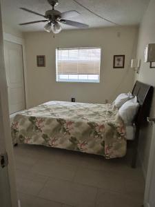 a bedroom with a bed and a ceiling fan at Clearwater Beach Getaway Clearwater in Clearwater