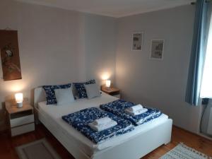 a bedroom with a bed with blue sheets and pillows at Apartament pod mewą in Gdynia