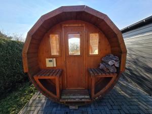 a circular wooden door with two benches in front at Fewo Möwe mit Sauna in Hafennähe in Breege