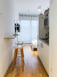 a kitchen with a table and a stool in a room at My Room Messe Munich Apartment in Munich