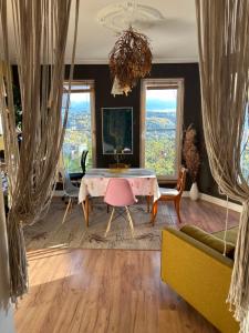 a living room with a table and chairs and windows at Rooms in an Apartment with Beautiful Views in Przemyśl