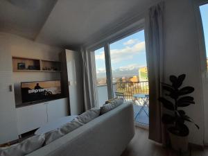 a living room with a couch and a large window at Apt 415 Svit in Jezersko