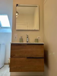 a bathroom with a sink and a mirror at Vichy Cosy T2 plein centre, thermes et parcs in Vichy