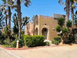 a house with palm trees in front of a street at DreamCatcher Homes in Mirleft