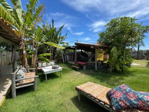 a yard with benches and a house with a table at Casa Pathuá Corumbau in Corumbau