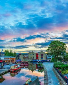 a group of boats are docked on a river at Corner House Studio in Skipton