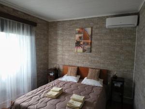 a bedroom with a bed and a brick wall at Casa Dos Mosteiros in Mosteiros