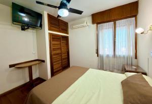 a bedroom with a bed and a flat screen tv at Hotel Villa Inés Mendoza in Mendoza