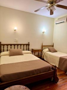 a bedroom with two beds and a ceiling fan at Hotel Villa Inés Mendoza in Mendoza +41 photos
