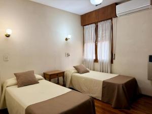 a hotel room with two beds and a window at Hotel Villa Inés Mendoza in Mendoza