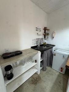 a kitchen with a counter and a sink and a refrigerator at Casa Pathuá Corumbau in Corumbau