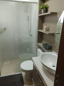 a bathroom with a toilet and a sink and a shower at Edifício Capri , apto 405 Canela RS in Canela +42 photos