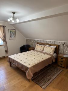 a bedroom with a large bed and a chair at B&B Millenium House 2 in Jezerce