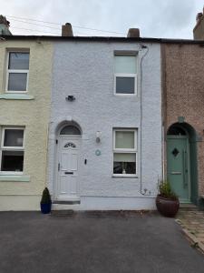 a white house with a green door and windows at Cottage in Sandwith in St Bees