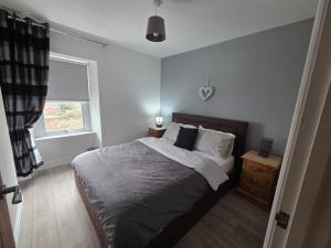 a bedroom with a large bed and a window at Cottage in Sandwith in St Bees