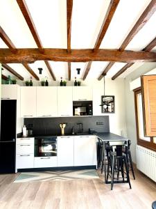a kitchen with white cabinets and a table with chairs at El Sueño de Celia 1 in Doña Juandi