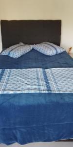 a blue bed with a blue comforter on it at Edifício Capri , apto 405 Canela RS in Canela