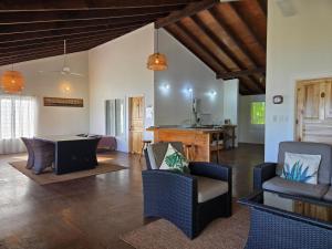 a living room with chairs and a table and a kitchen at Mystic Sands in Utungake