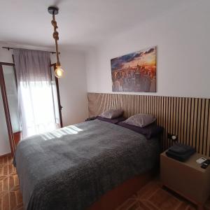 a bedroom with a bed and a painting on the wall at Casa Lolo in Algodonales