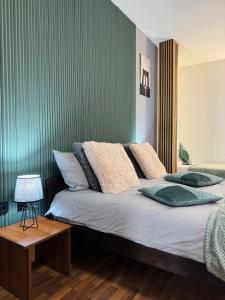a bedroom with a bed with a green wall at Zulu Apartments and Studios in Kumanovo