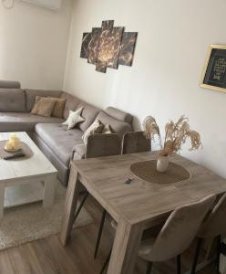 a living room with a wooden table and a couch at Apartmani Milić Banja Koviljača in Banja Koviljača