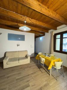 a living room with a table and a couch at Ginepro Home Holidays in Villanova Monteleone +18 photos