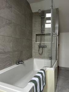 a bathroom with a bath tub and a shower at Lilyscape At Whitehead in Whitehead