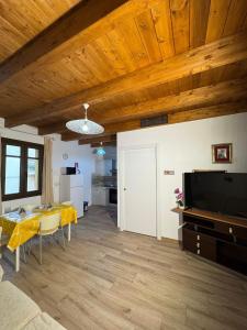 a living room with a dining table and a television at Ginepro Home Holidays in Villanova Monteleone