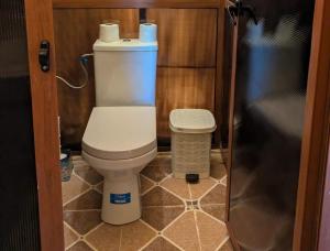 a small bathroom with a toilet and a trash can at Achabou Desert Camp in Merzouga +17 photos