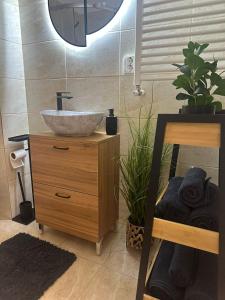 a bathroom with a bowl sink on a wooden dresser at DIAMOND MIRAGE Militari Residence in Chiajna +45 photos