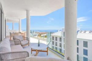 a living room with a couch and a table on a balcony at Luxury Apartment Higueron in Fuengirola