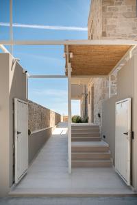 a hallway of a building with white doors and stairs at Pietra Di Sabbia Villas in Palaiochora +74 photos
